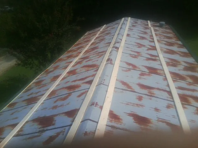 Rusted metal roof panels with new wood purlins before replacement — Storm Damage Roof Repair in Creedmoor by Roofing Brothers