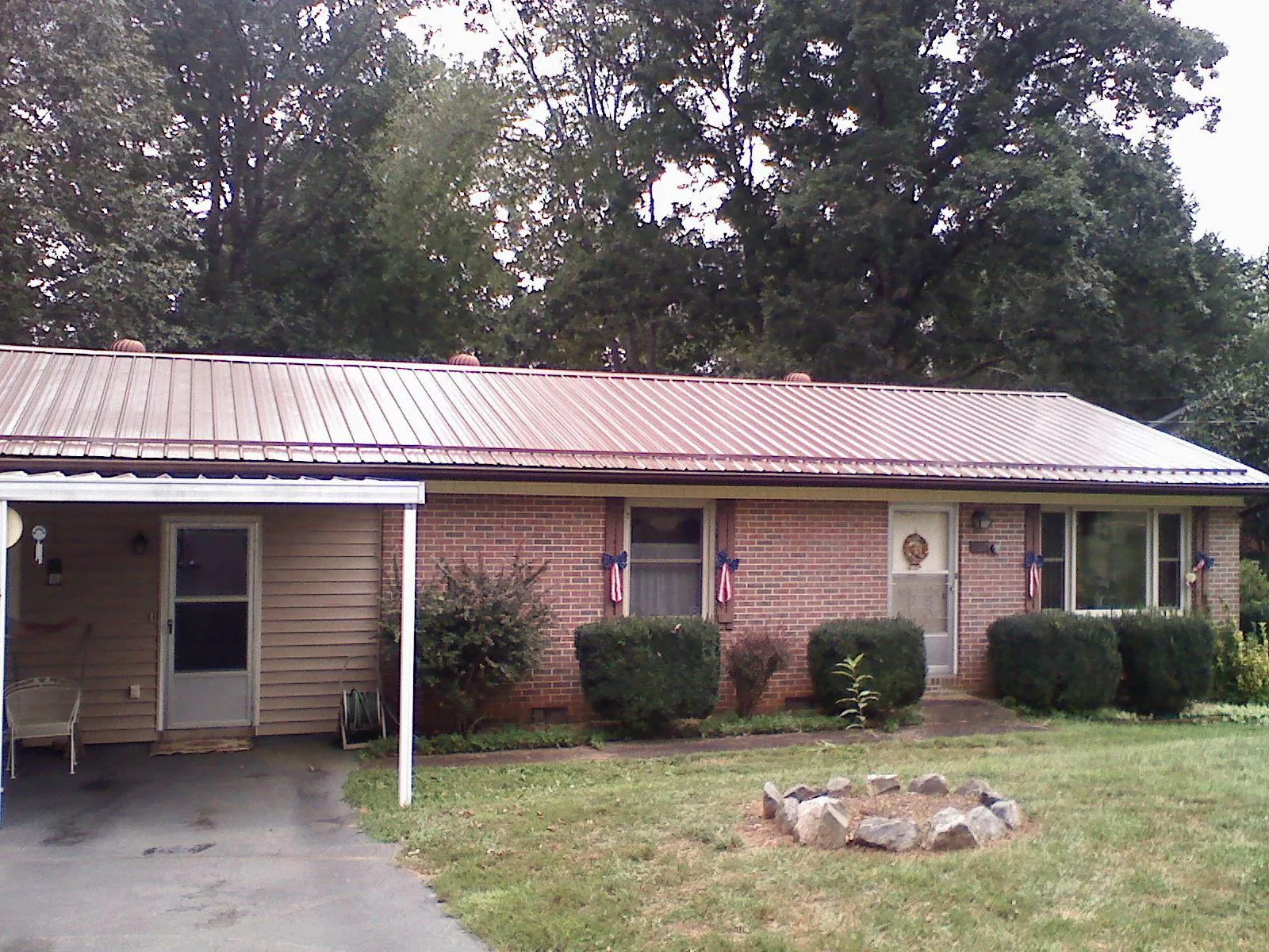 Bronze metal roof and carport on a brick ranch home — Roof Repair work by our crew in Creedmoor