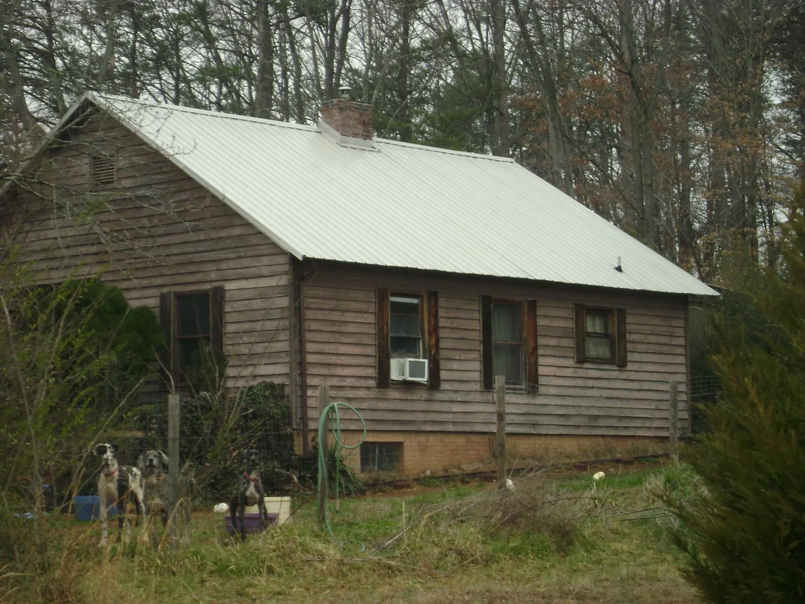 White metal roof on an old wood sided farmhouse, from a Asphalt Shingle Roof Repair job in Creedmoor